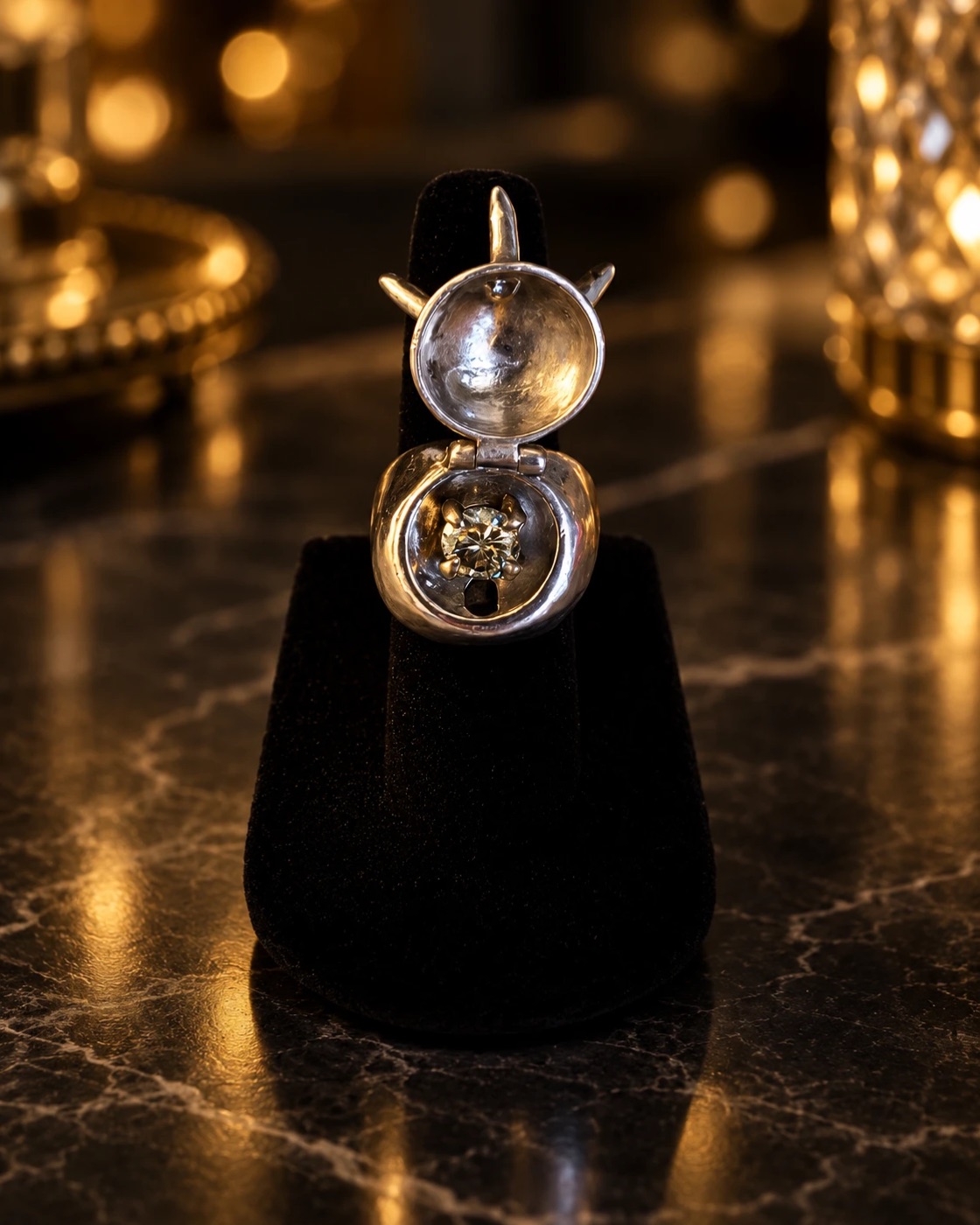 The spiked dome ring opened on its hinge to reveal a round stone set inside the hidden chamber